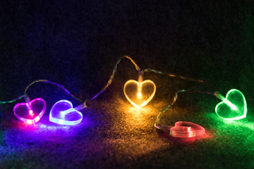 Lichterkette mit bunten Herzen - Romantisch vor schwarzem Hintergrund