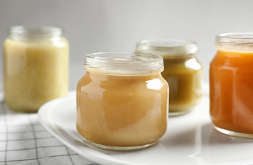 Jars with healthy baby food on table