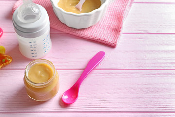 Composition with jar of healthy baby food on wooden table