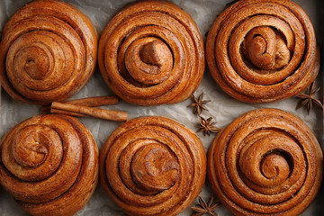Sweet cinnamon rolls on parchment paper