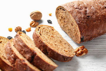 Yummy fresh bread with walnut and raisins on wooden background