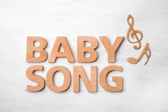 Text BABY SONG made of letters on wooden background