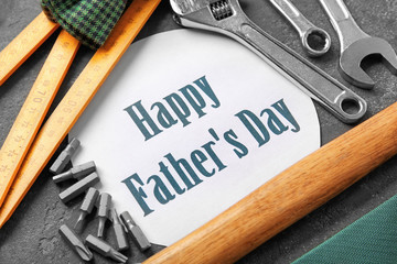 Set of tools with greeting card on dark background. Father's Day concept