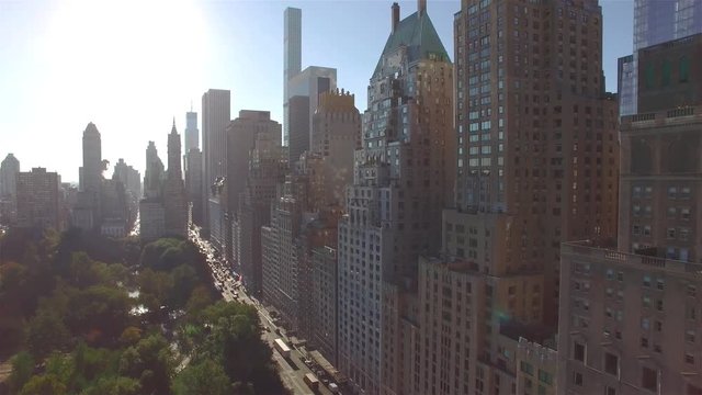 Aerial real time shot, camera is flying above Central Park and approaching to the intersection of West 95th Street and Fifth Avenue in New York. Camera is slowly moving forward.
