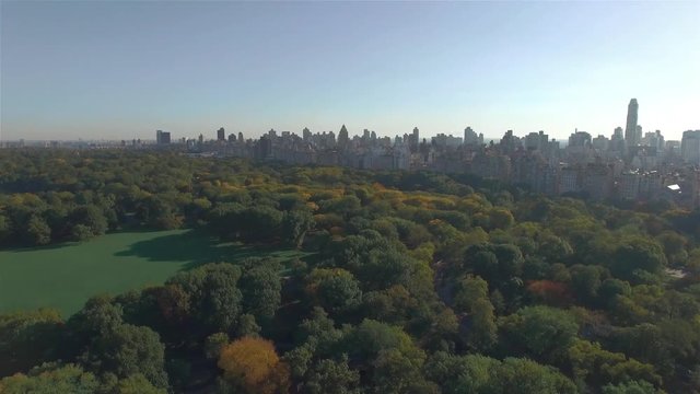 Aerial panoramic overview of Central Park in New York. Camera is flying above Central Park, turning around and finishing the movement towards the intersection between Fifth Avenue and West 95th Street