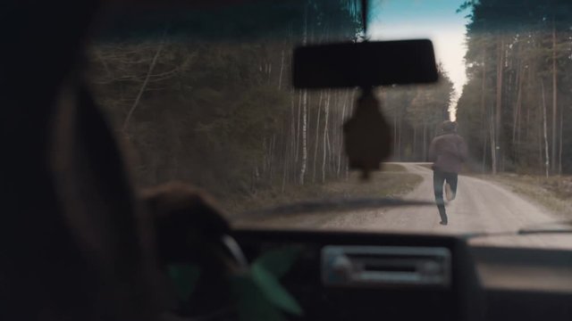 Man chased by a car through the forest road