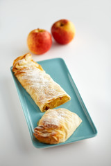 Apfelstrudel und Äpfel im Hintergrund