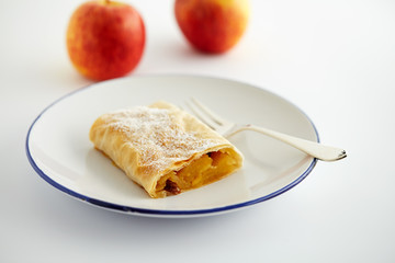 Apfelstrudel und Äpfel im Hintergrund