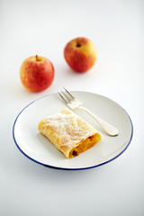 Apfelstrudel und Äpfel im Hintergrund