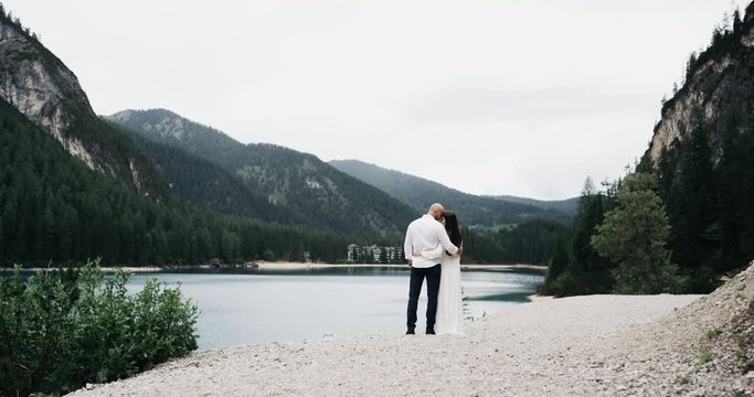 Beautiful couple in love ,staying close-up with each other,background amazing lake and perfect green mountains.RED epic
