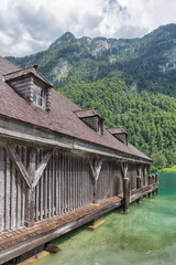 Fototapeta na wymiar Boathouse at German Konigssee with steep mountains and clear transparant water