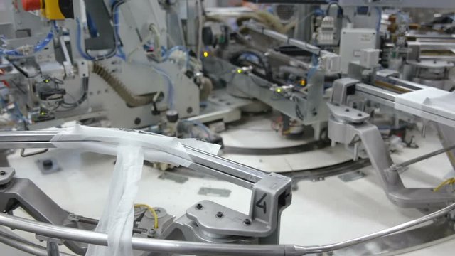 Robotic Arm in Action. Hosiery Manufacturing. Robotic arm working on factory assembly line.Industrial Mechatronics. Automated Production in Factory. Tights Manufacturing Workshop. Industrial Robot.