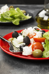 Greek salad feta, cherry tomatoes, olives, cucumbers on a dark background
