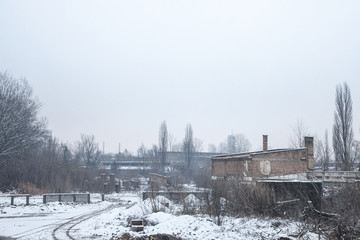 Abandoned factories and warehouses under the snow in Eastern Europe, in Pancevo, Serbia, former Yugoslavia, during a cold winter afternoon.
