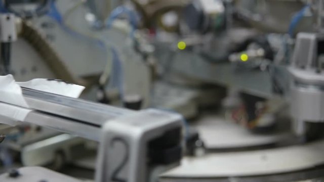 Robotic Arm in Action. Hosiery Manufacturing. Robotic arm working on factory assembly line.Industrial Mechatronics. Automated Production in Factory. Tights Manufacturing Workshop. Industrial Robot.