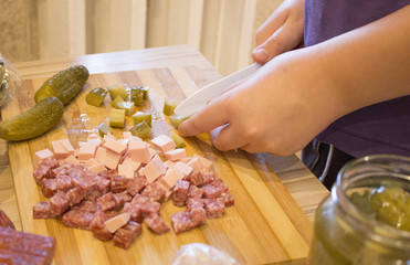 the boy cut the ingredients for the pizza