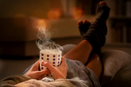 Woman with drink lying on sofa