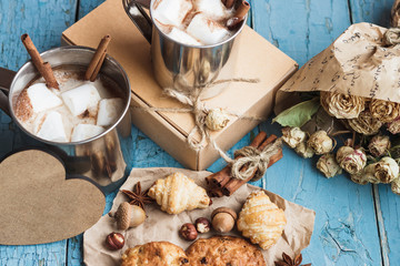 Metal cups with cacao and marshmallow and different cookies
