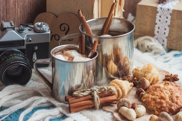 Metal cups with cacao and marshmallow and different cookies