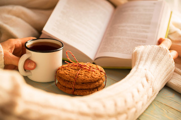 Girl reading book and drinking tea in winter