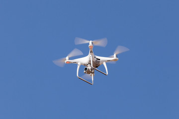 Drone copter with high resolution digital camera flying. Blue sky background
