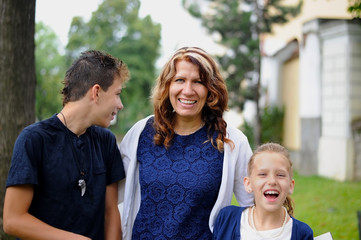 Fototapeta premium Mom is having a rest in the city with her children. They are happy and laugh