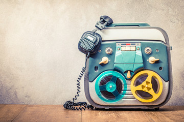 Retro old reel to reel tape recorder and headphones front concrete wall background. Vintage...