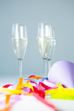 Champagne flutes with party hat and streamers