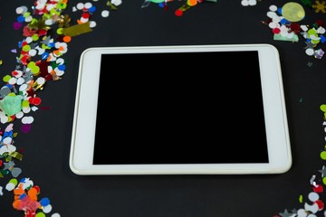 Digital tablet surrounded by confetti