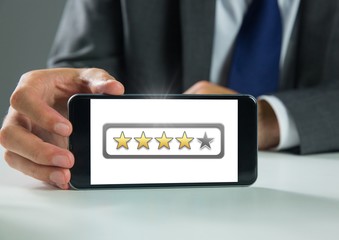 Hand holding phone with star ratings review