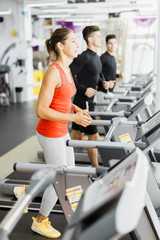 Group of young people using treadmills in a gym