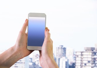 Hand holding phone with city