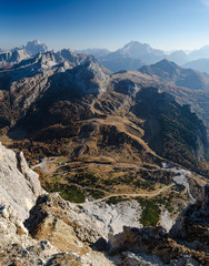 Aerial panoramic view of rocky mountains and mountain road in the valley