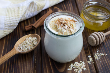 Milk yogurt with banana,oat flakes and cinnamon on the  wooden background