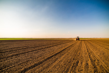Farmer fertilizing arable land with nitrogen, phosphorus, potassium fertilizer - obrazy, fototapety, plakaty