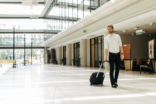 Handsome business holding a trolley