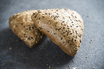grain bread on a dark background and crumbs 