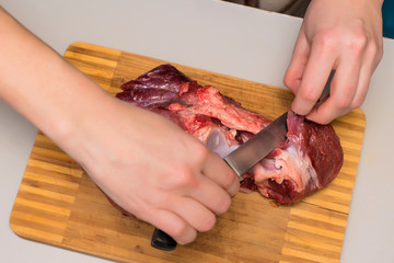 cutting meat with hands