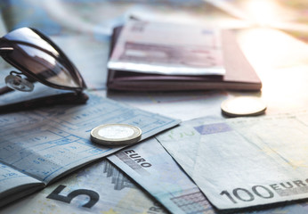 Euro banknotes and passport on the background of the card and sunglasses. The concept of travel.