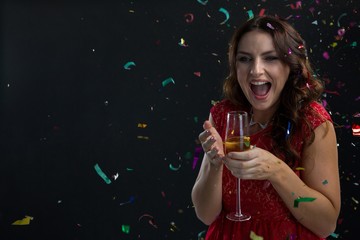 Woman celebrating the New year with falling confetti streamers