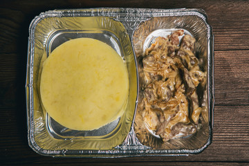 Healthy lunch in aluminum foil package. Top view. Lunch box with food ready to go for work or...