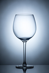 One empty wineglass for red wine on diffusion lit background