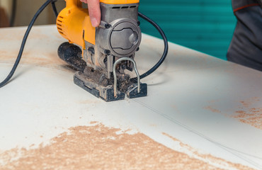 Electric jigsaw cuts chipboard