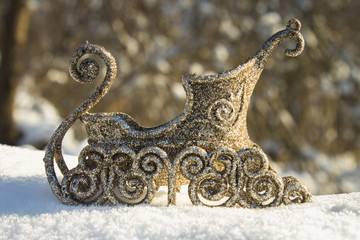 Golden sleigh in the snow. Christmas toys.