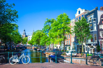 Obraz premium Beautiful canal and traditional bikes in old city of Amsterdam, Netherlands, North Holland province.