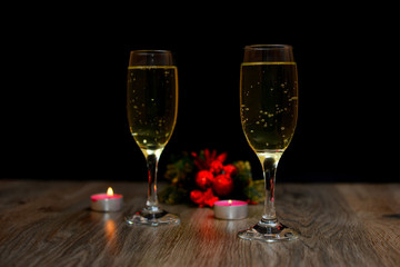 glasses of champagne and Christmas ornaments on dark wooden background