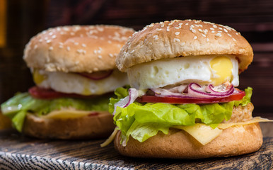 hamburger with egg on a wooden board
