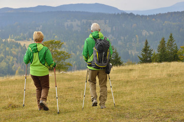 Senior tourist couple hiking at the beautiful mountains
