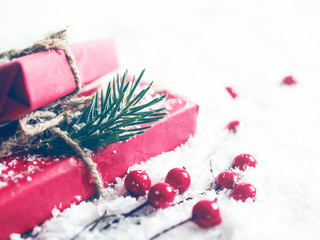 Red gift boxes and christmas fir-tree decoration on a snow surface, soft focus. Christmas background