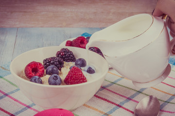 Oatmeal with raspberries, blackberries, blueberries and milk - rustic healthy breakfast